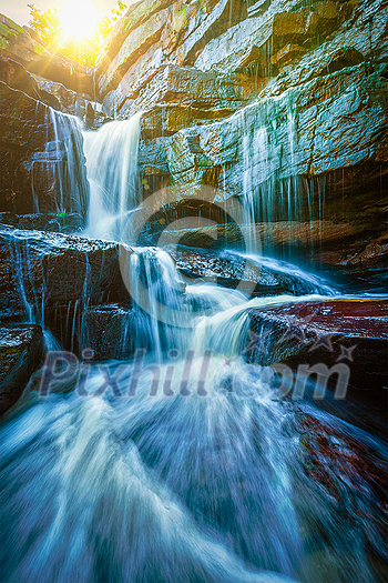 Tropical waterfall with sun rays. With lens flare and light leak Tropical waterfall with sun rays. With lens flare and light leak
