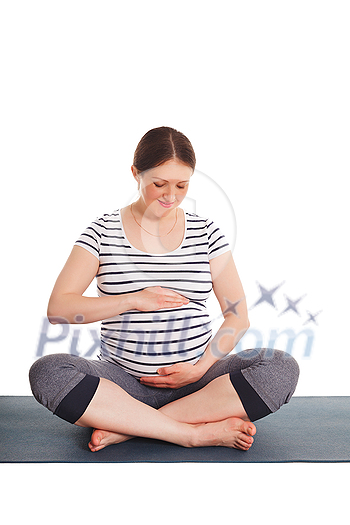 Pregnancy yoga exercise - pregnant woman doing asana Sukhasana easy yoga pose embracing her belly isolated on white background Pregnancy yoga exercise - pregnant woman doing asana Sukhasana easy yoga pose embracing her belly isolated on white background