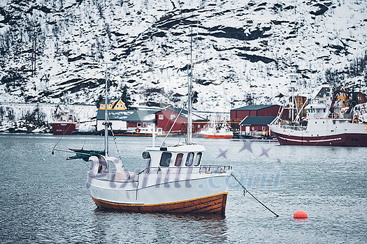 Ship fishing boat in Hamnoy fishing village on Lofoten Islands, Norway with red rorbu houses. With falling snow Ship fishing boat in Hamnoy fishing village on Lofoten Islands, Norway with red rorbu houses. With falling snow
