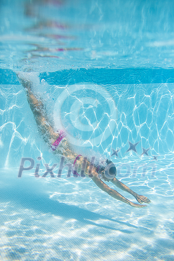 Young woman in a swimming pool performing some synchronized swimming drills Young woman in a swimming pool performing some synchronized swimming drills