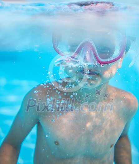 Cute little boy in a swimming pool, diving, swimming underwater, having fun Cute little boy in a swimming pool, diving, swimming underwater, having fun