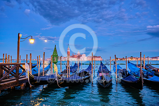 Romantic vacation Venice travel background - gondolas in lagoon of Venice by San Marco square with Basilica San Giorgio Maggiore Church seen across the Venice lagoon with full moon. Venice, Italy Romantic vacation Venice travel background - gondolas in lagoon of Venice by San Marco square with Basilica San Giorgio Maggiore Church seen across the Venice lagoon with full moon. Venice, Italy