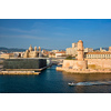 Marseille Old Port and Fort Saint-Jean and Museum of European and Mediterranean Civilisations and Marseille Cathedral on sunset with passing boat. Marseille, France
