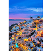 Famous greek iconic selfie spot tourist destination Oia village with traditional white houses and windmills in Santorini island in the evening blue hour, Greece