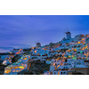 Famous greek iconic picturesque tourist destination Oia village with traditional white houses and windmills in Santorini island in the evening blue hour, Greece