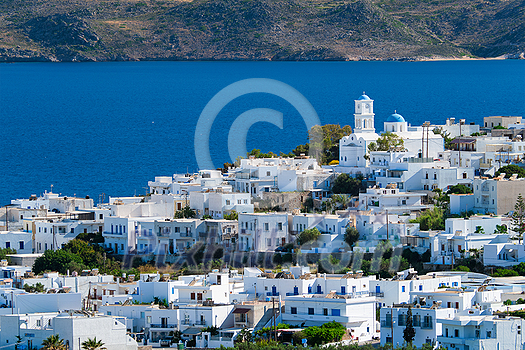 View of Plaka village with traditional Greek church and white painted houses and ocean coast. Milos island, Greece View of Plaka village with traditional Greek church and white painted houses and ocean coast. Milos island, Greece