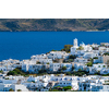 View of Plaka village with traditional Greek church and white painted houses and ocean coast. Milos island, Greece