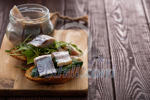 Herring sandwich (traditional Danish smorrebrod) on cutting board. Copyspace. Herring sandwich (traditional Danish smorrebrod) on cutting board. Copyspace.
