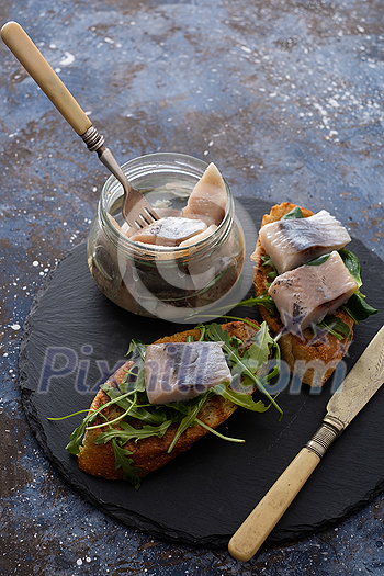 Herring sandwich (traditional Danish smorrebrod) on cutting board. Herring sandwich (traditional Danish smorrebrod) on cutting board.