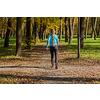 Nordic walking adventure and exercising concept - woman hiking withnordic walking poles in park