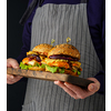 Chicken burger with pineapple. Men's hands hold a tray with a cheeseburger.