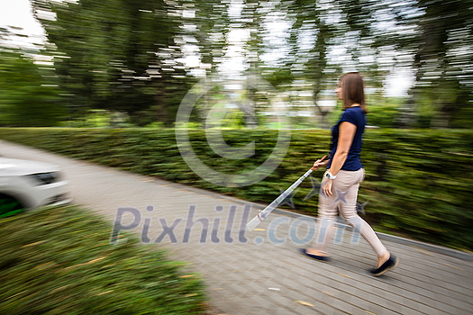 Blind woman walking on city streets, using her white cane Blind woman walking on city streets, using her white cane
