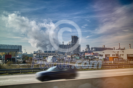 Creative landscape with large power plant on the background of blue cloudy sky and blurred car on a forefront in Budapest, Hungary. Creative landscape with large power plant on the background of blue cloudy sky and blurred car on a forefront in Budapest, Hungary.