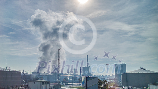 Industrial landscape with strong atmosphere wastes emission above large power plant or factory on a background of cloudy sunny sky in Budapest, Hungary. Industrial landscape with strong atmosphere wastes emission above large power plant or factory on a background of cloudy sunny sky in Budapest, Hungary.