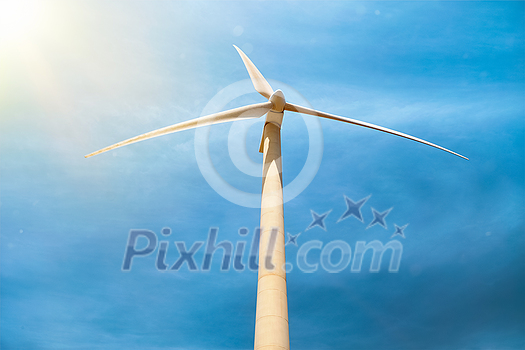 Green renewable alternative energy concept - wind generator turbine generating electricity in blue sky