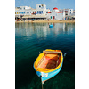Blue fishing boat in port harbor of Chora town on Mykonos island with orthodox church in background, Greece