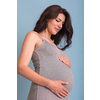 Portrait of happy pregnant woman with hands on belly isolated over blue background