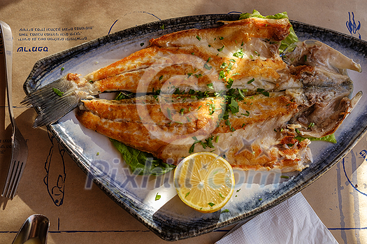 Grilled fish with lemon on a plate Grilled fish with lemon on a plate
