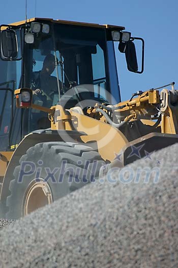 Tractor pushing pebbles