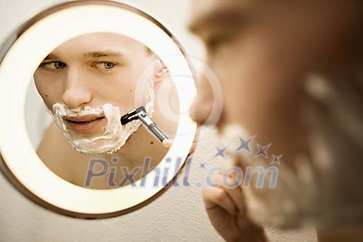 Man shaving in front of the mirror Man shaving in front of the mirror