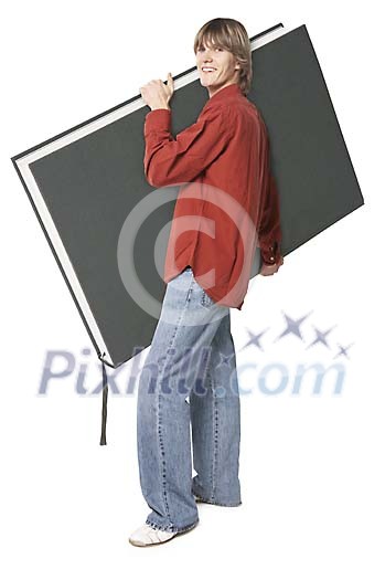 Boy carrying a big book Boy carrying a big book