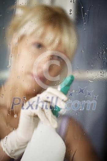 Woman spraying the window Woman spraying the window