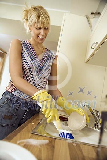 Woman in the kitchen doing the dishes Woman in the kitchen doing the dishes