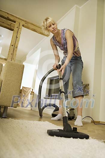 Woman vacuuming the floor Woman vacuuming the floor