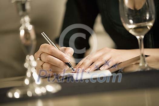 Woman signing a bill Woman signing a bill
