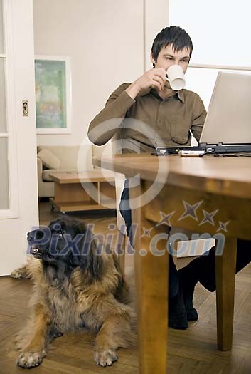 Man sitting on the table, dog on the floor Man sitting on the table, dog on the floor