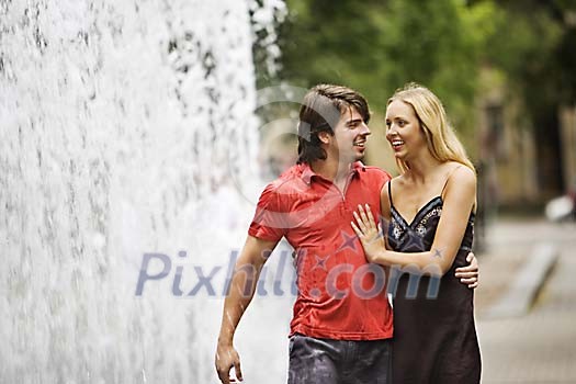 Couple walking in the park near fountain Couple walking in the park near fountain