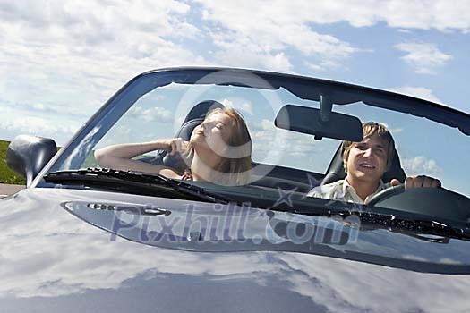 Couple driving in convertible car Couple driving in convertible car