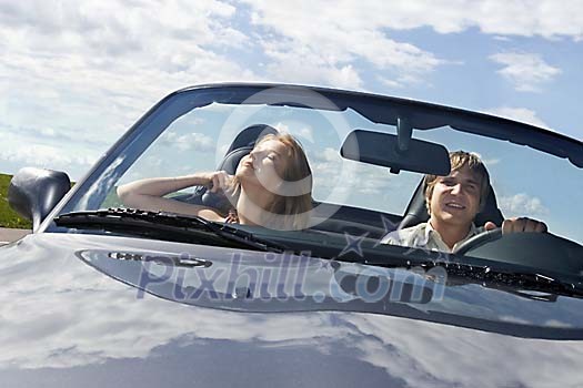 Couple driving in convertible car