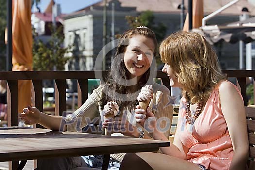Two women having icecream and talking Two women having icecream and talking