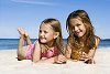 Two girls lying on the sand