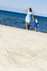 Woman and child walking on the sand