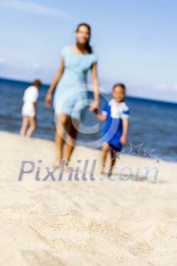 Woman and child walking on sand Woman and child walking on sand