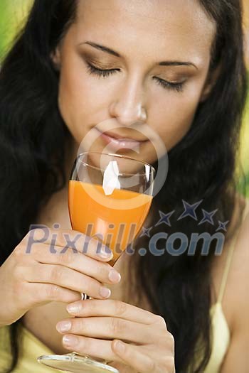 Woman smelling a glass of juice Woman smelling a glass of juice