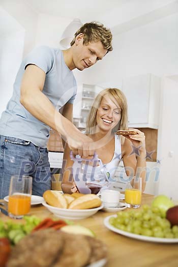 Man pouring coffee for woman