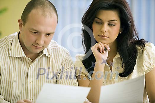 Man and woman reading documents Man and woman reading documents