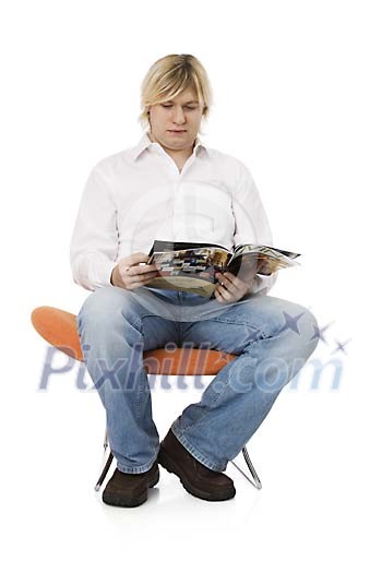 Man sitting and looking through the magazine Man sitting and looking through the magazine
