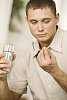 Man holding a pill and a glass of water