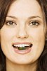 Woman holding a pill between her teeth