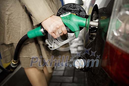 Woman refueling her car Woman refueling her car