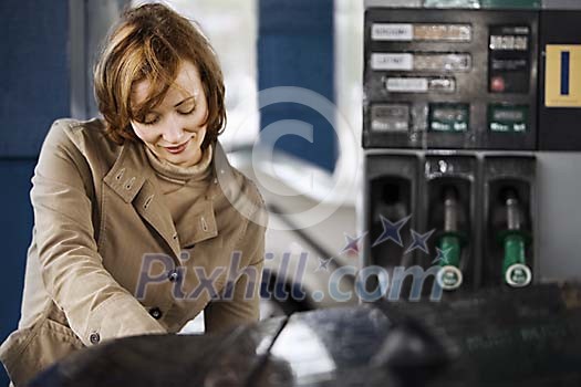 Woman refueling her car Woman refueling her car