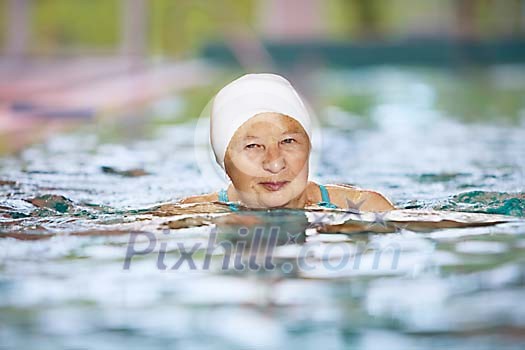 Older woman swimming in the pool Older woman swimming in the pool