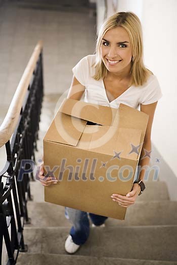 Woman carrying a box up the stairs