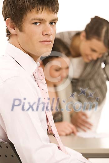 Businessman up front and two women at the back Businessman up front and two women at the back