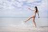 Woman splashing water with her foot at the beach