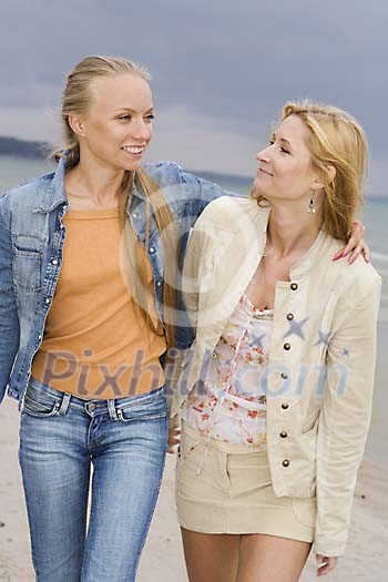 Two women walking at the beach Two women walking at the beach